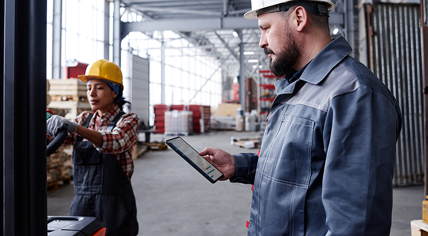 Bearded foreman or picker with tablet checking online orders in warehouse